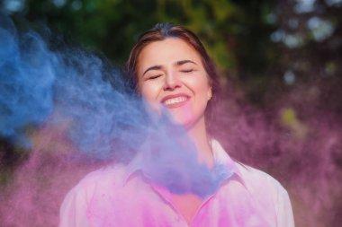 Pembe ve mavi boya Holi patlayan ile oynarken olumlu kafkas kadın 