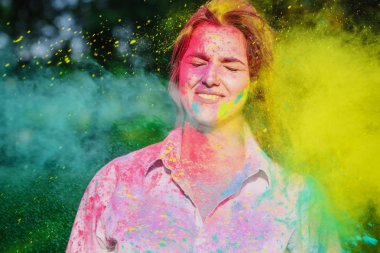 Holi Festivali sarı ve yeşil kuru boya ile oynarken gülümseyen beyaz kadın portre vurdu. Boşaltmak