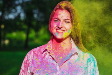 Holi Festivali renkli kuru boya ile oynayan neşeli beyaz esmer kız 