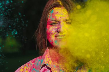 Holi Festivali renkli kuru boya ile oynayan neşeli beyaz esmer kız. Metin için yer