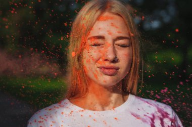 Holi Festivali turuncu kuru boya patlayan ile poz harika beyaz sarışın kız