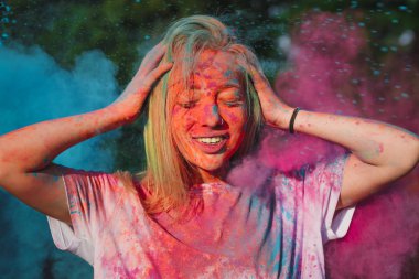 Bir mavi ve pembe kuru Holi boya bulutu içinde poz romantik sarışın kız closeup çekim