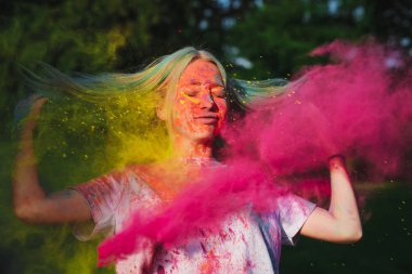 Sarı ve pembe Holi boya patlayan ile poz saç uçan ile şaşırtıcı genç kadın