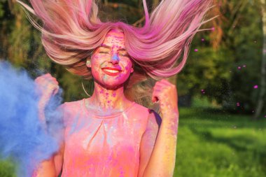Kuru boya ile Holi oynarken rüzgar tarafından şişirilmiş saçlı güzel beyaz model 