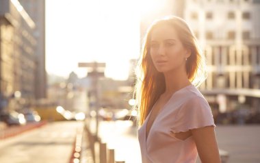 Sihir güneş ışınlarının Avenue poz şık elbiseli sarışın kız. Boş alan