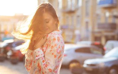 Bluz ve akşam şehir arka plan poz pembe ceket giyen şehvetli esmer kadın. Boş alan