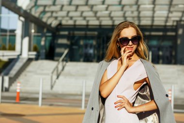 Baştan çıkarıcı sarışın kadın şık bardaklarda avenue güneşli bir günde poz. Boş alan