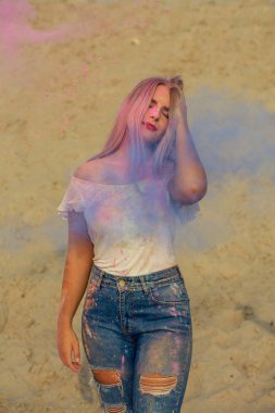 Pembe ve mavi kuru boya Holi çölde, bir bulut poz ihale sarışın kadın