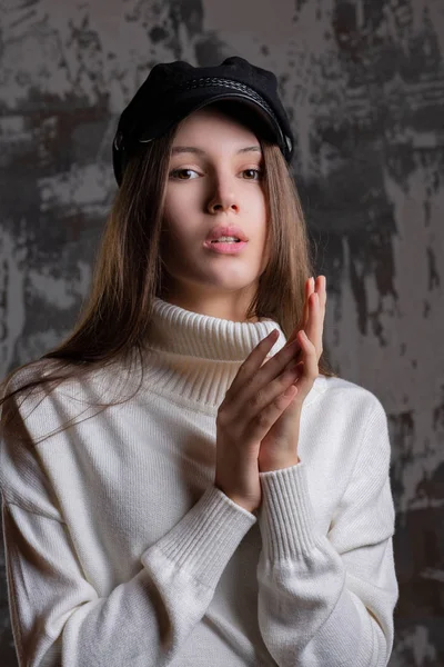 驚くべきブルネットのモデルは スタイリッシュなキャップでのポーズとニットのセーターのテスト シュート — ストック写真