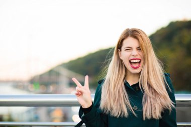 Duygusal sarışın model yeşil ceket gösteren barış gasture giyiyor. Boş alan