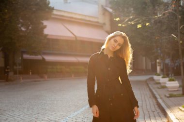 Yemyeşil kıvırcık saçlı güneş parlama ile poz zarif sarışın kadın portre yaşam tarzı. Boş alan