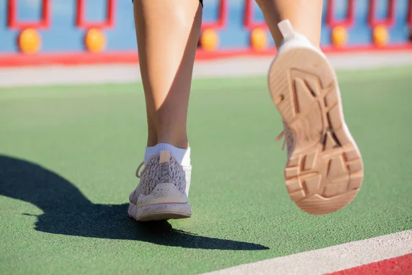 Closeup shot of woman\'s feet jogging at the bridge in sun light