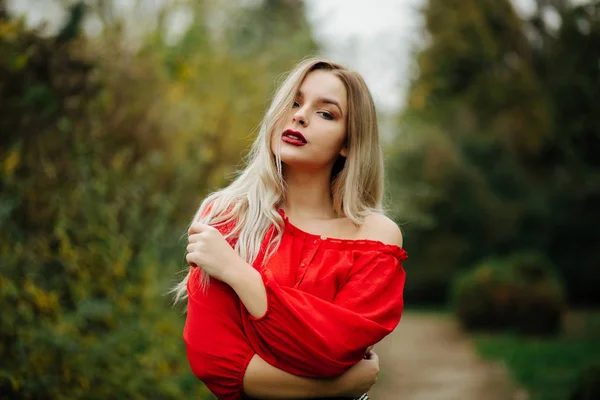 Linda Modelo Loira Blusa Vermelha Posando Com Ombro Nas Árvores — Fotografia de Stock