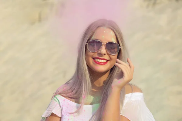 裸の肩と砂漠でピンク乾燥塗装ホーリーで遊んでメガネとシャツを身に着けている表情豊かなブロンドの女性 — ストック写真