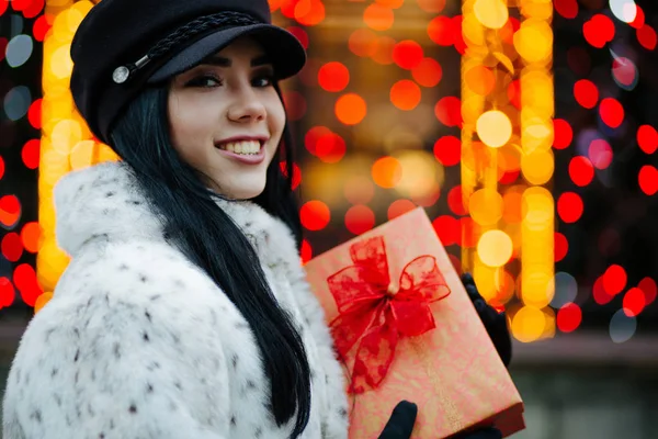 Happy Smiling Brunette Girl Wearing Cap Fur Coat Holding Gift — Stock Photo, Image