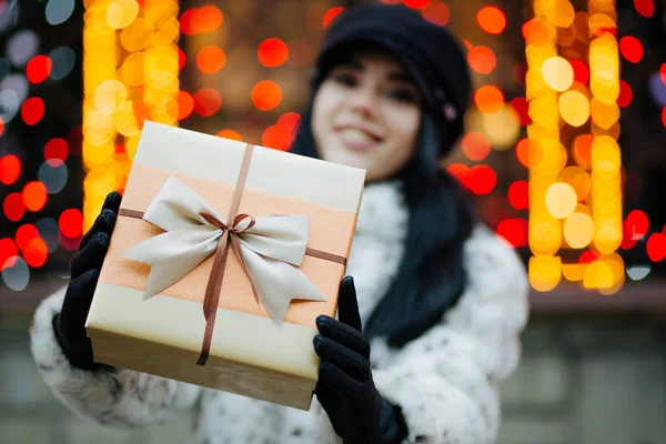 Coole Junge Frau Mit Pelzmantel Und Mütze Zieht Eine Geschenkschachtel — Stockfoto