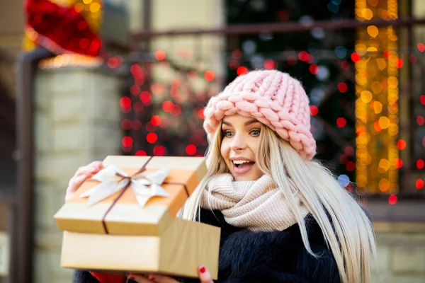 Excited Blonde Woman Wearing Knitted Cap Warm Coat Holding Gift — Stock Photo, Image