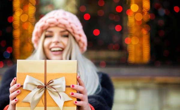 Flirty Blonde Woman Wearing Fur Coat Knitted Cap Pulls Gift — Stock Photo, Image