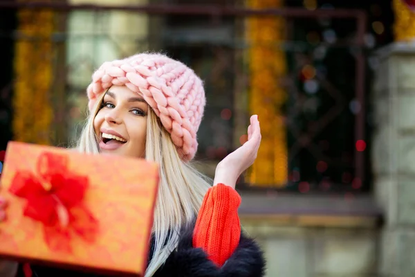 Positive Young Woman Wearing Fur Coat Cap Pulls Gift Box — Stock Photo, Image