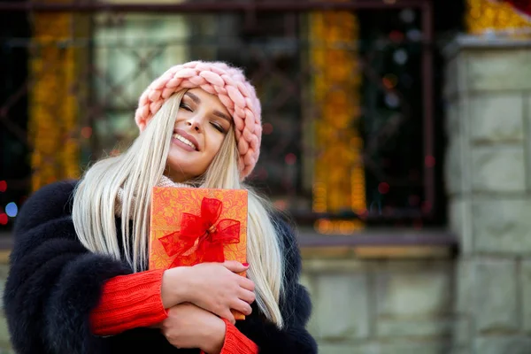 Magnificent Blonde Woman Wearing Knitted Cap Warm Coat Holding Gift — Stock Photo, Image