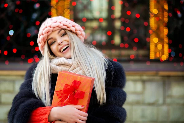 Wonderful Blonde Woman Wearing Knitted Cap Warm Coat Holding Gift — Stock Photo, Image