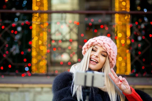 Экспрессивная Блондинка Розовой Кепке Делает Селфи Городской Улице Украшенной Гирляндами — стоковое фото