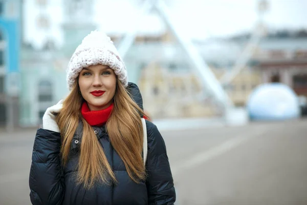 Stunning blonde woman with red lipstick wearing knitted cap, enjoying city walk. Space for text