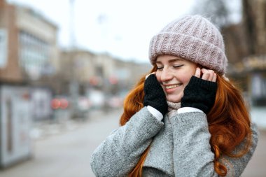 Closeup muhteşem zencefil modeli, örme kap ve city adlı yürüyüş eşarp giymiş uzun saçlı vurdu. Metin için yer
