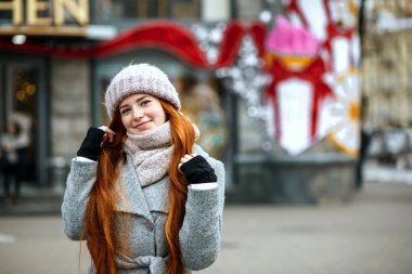 Uzun saçlı şehirde sıcak giysiler giyiyor neşeli zencefil kadın kentsel portresi. Metin için yer