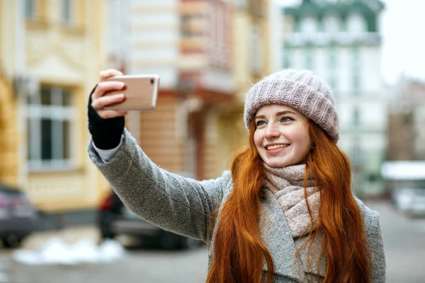 Wesoły Czerwony Modelu Głowy Zimowe Ubrania Biorąc Selfie Jej Telefon — Zdjęcie stockowe