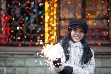 Neşeli esmer kadın bengal ışıklar açık ile eğleniyor. Boş alan