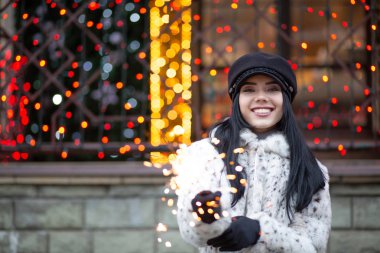 Mutlu esmer kız bengal ışıklar açık ile eğleniyor. Boş alan