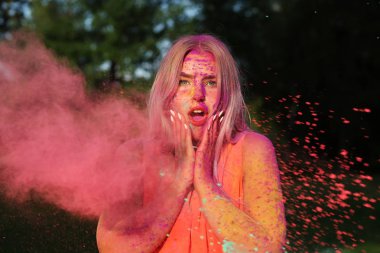 Holi Festivali kuru pembe boya bulutu poz Turuncu elbise sürpriz genç kadın 