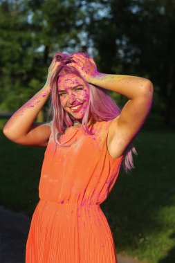Poz güzel sarışın kadın parkta renkli kuru boya ile kaplı