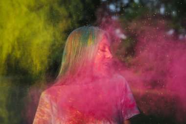 Holi Festivali sarı ve pembe kuru toz patlayan ile oynarken harika sarışın kadın 