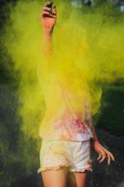 Holi Festivali sarı kuru toz patlayan ile oynarken güzel sarışın kadın 