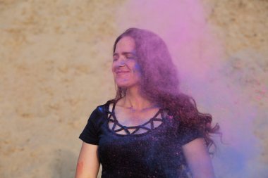 Neşeli genç model onun mavi ve pembe Holi toz, çölde etrafında patlayan ile poz