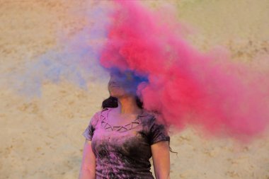 Uzun dalgalı saçlı pembe ve mavi kuru Holi toz ile eğleniyor çöl çok esmer modeli