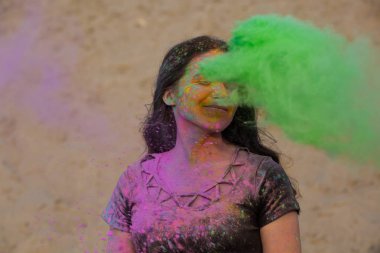 Yeşil kuru Holi toz ile eğleniyor çöl uzun dalgalı saçlı güzel esmer kadın