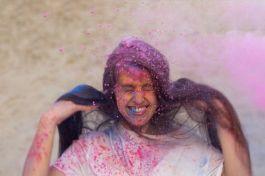 Çölde pembe kuru Holi toz ile oynarken uzun saçlı esmer model çekici
