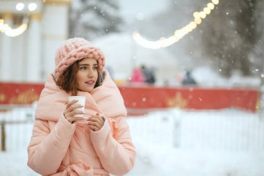 Kış Kiev'de adil Noel sıcak çay içme sıcak trendy kıyafeti giymiş çekici genç kadın portresi. Boş alan