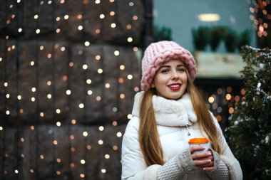Kış Street sıcak kahve içme sıcak trendy kıyafeti giymiş güzel esmer genç kadının portresi. Boş alan