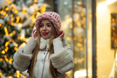 Muhteşem sarışın kadın kırmızı dudaklı hacimsel şapka ve sokakta yürürken kış ceket giyen çelenk ile dekore edilmiştir. Boş alan