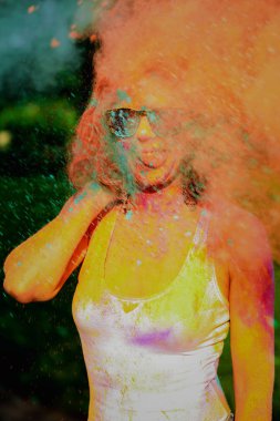 Bir bulut Holi renkleri Festivali'nde turuncu kuru boya eğleniyor komik Kızıl saçlı kadın