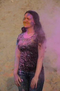 Holi Festivali çöl zevk çekici esmer modeli. Kadın pembe boya patlayan ile poz