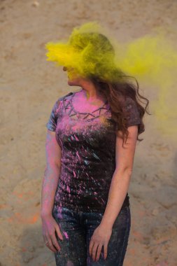 Holi Festivali çöl zevk muhteşem esmer modeli. Kadın sarı boya patlayan ile poz
