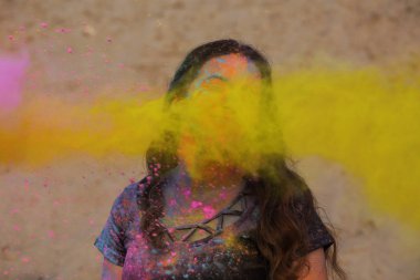 Esmer kadın zevk Holi festival çöl, ne yapıyorsun? Kadın sarı boya patlayan ile poz
