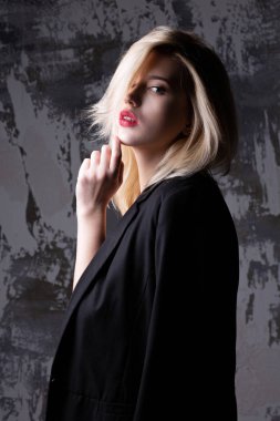 Ceket ve gölgeler ile stüdyoda poz sutyen giyen moda sarışın kadın