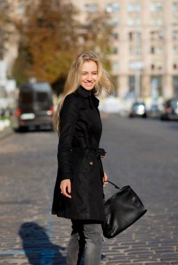 Sıcak havanın tadını, sokakta yürürken mutlu sarışın kız portresi güneşli bahar