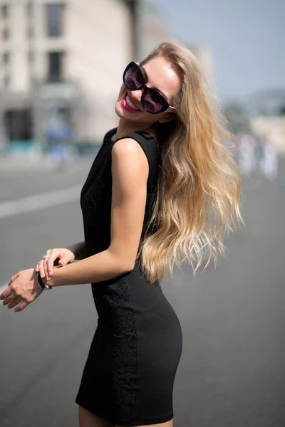 Очаровательная Улыбающаяся Блондинка Черном Платье Солнечных Очках Идущая Солнечной Улице — стоковое фото